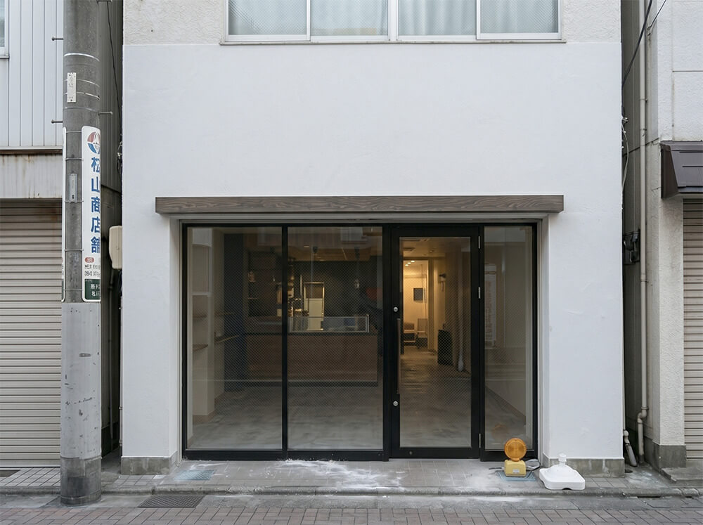 「Grill 天（TEN）Aoyama」様の看板施工前（ビフォー）の店舗外観。サインのない白い壁面とガラスファサードの状態。