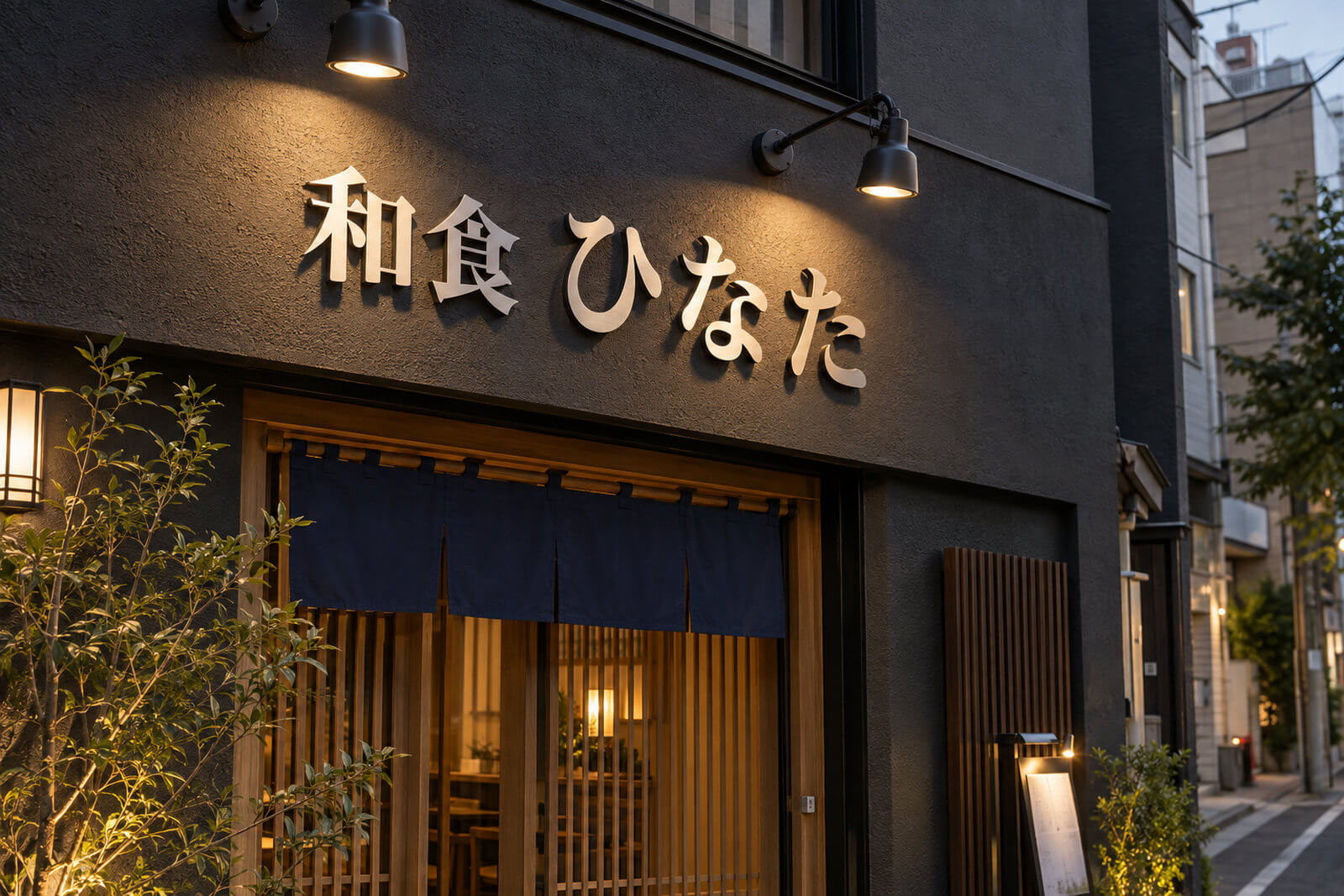 飲食店のファサードに浮かし取付した大きなステンレス切文字の店名とスポットライト