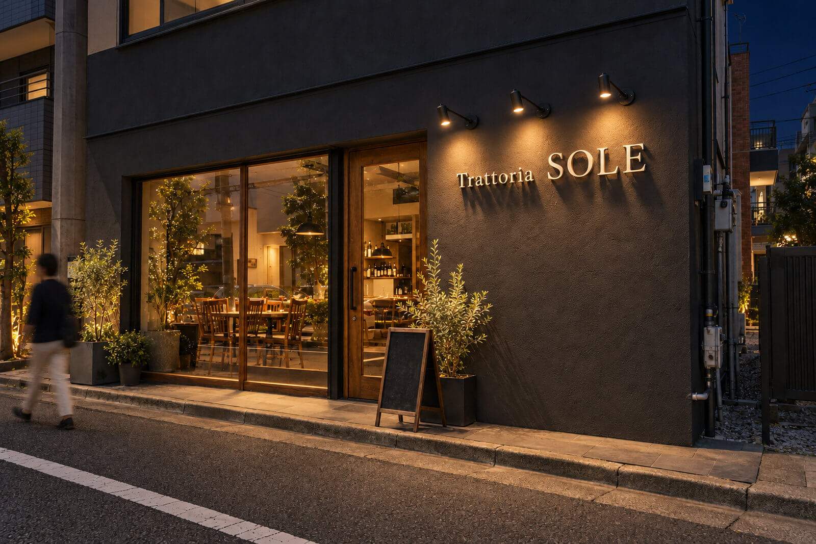夜の店舗外壁でスポットライトに照らされ影が伸びるステンレス切文字