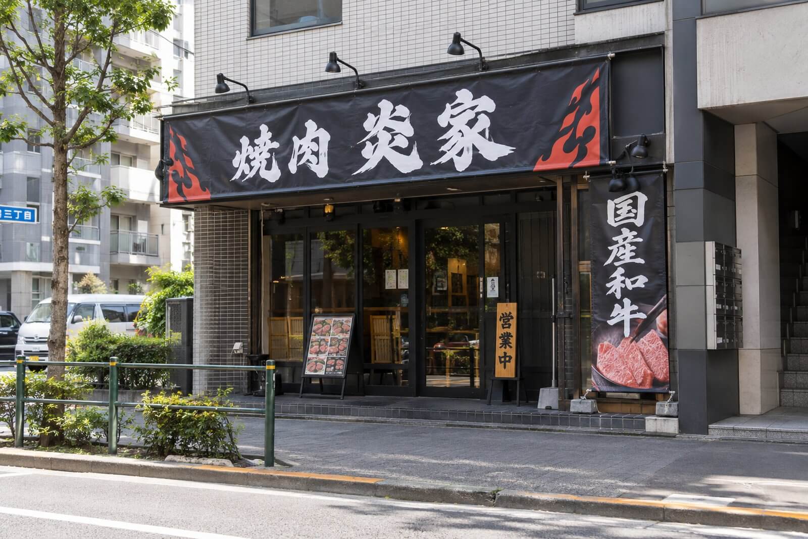 昼間の焼肉店の軒下に設置した店頭幕とスポットライト