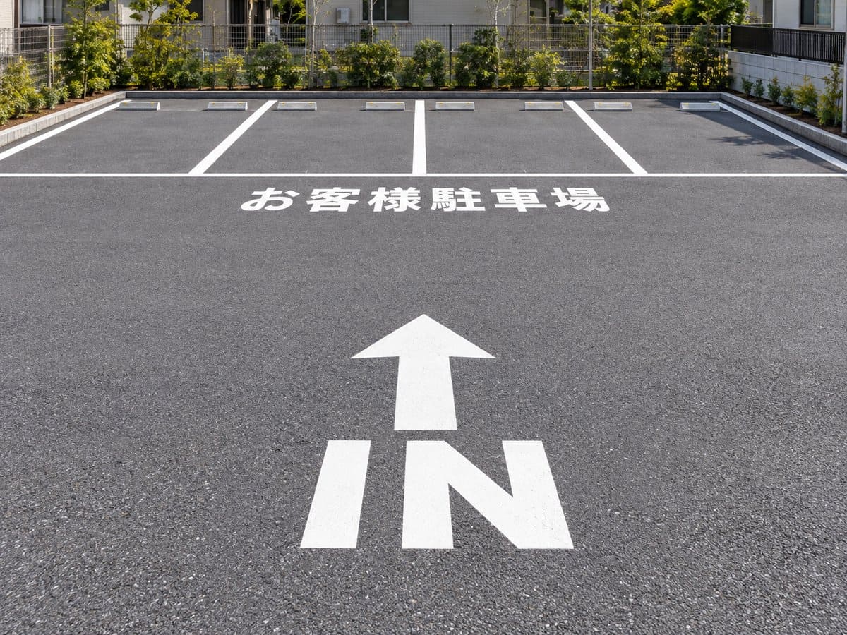 車屋さんの駐車場の路面に貼った「IN」の矢印と「お客様駐車場」の路面表示の例
