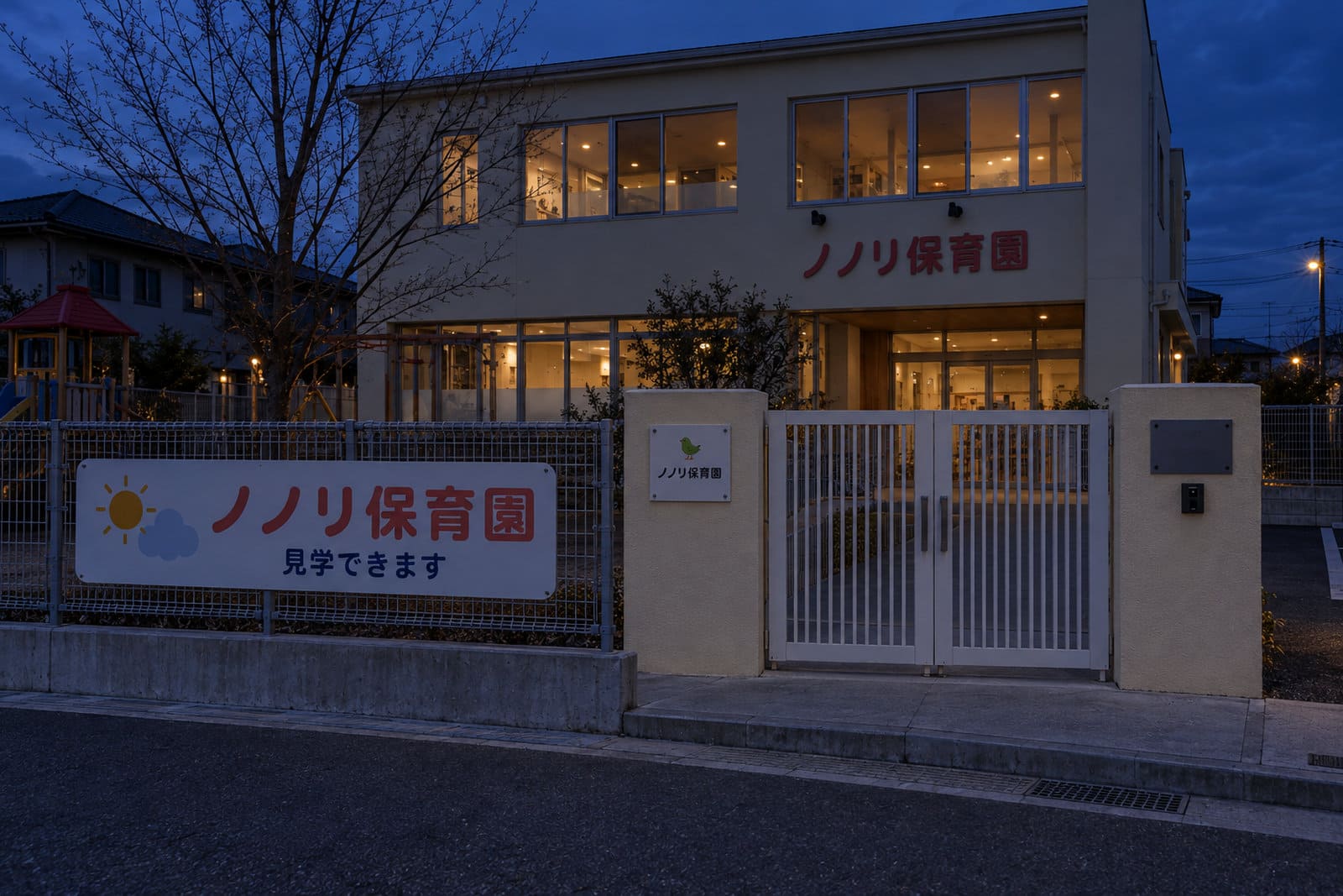 冬の夕方、照明のない保育園の門。園名の看板が暗くて読みにくい