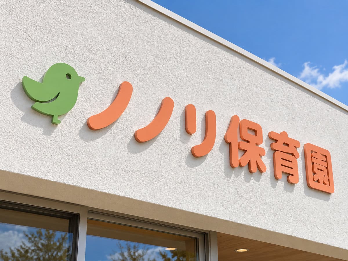 保育園の白い外壁に付けた、丸みのある書体のやわらかいオレンジ色の立体文字の園名