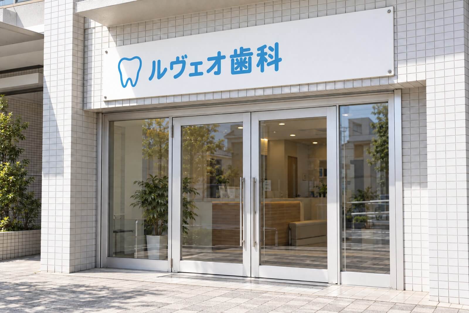 同じ看板に新しいシートを貼り、白地と水色の文字が鮮やかになった歯科医院の入口