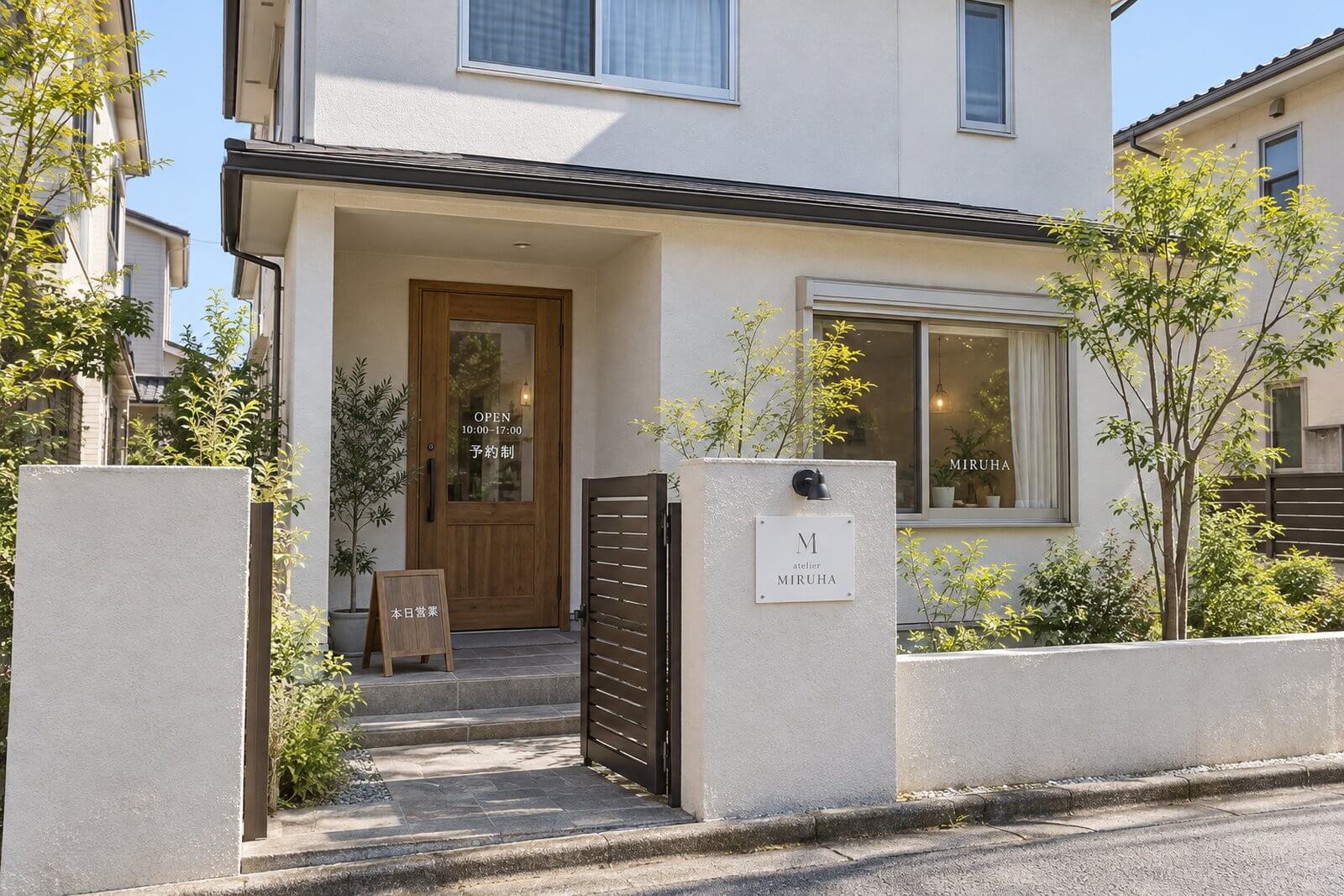 住宅街の戸建ての自宅サロン。門柱に付けた表札サイズの白いアクリル看板と小さなライト、玄関ドアの営業時間のステッカー、門の内側の小さなスタンド看板